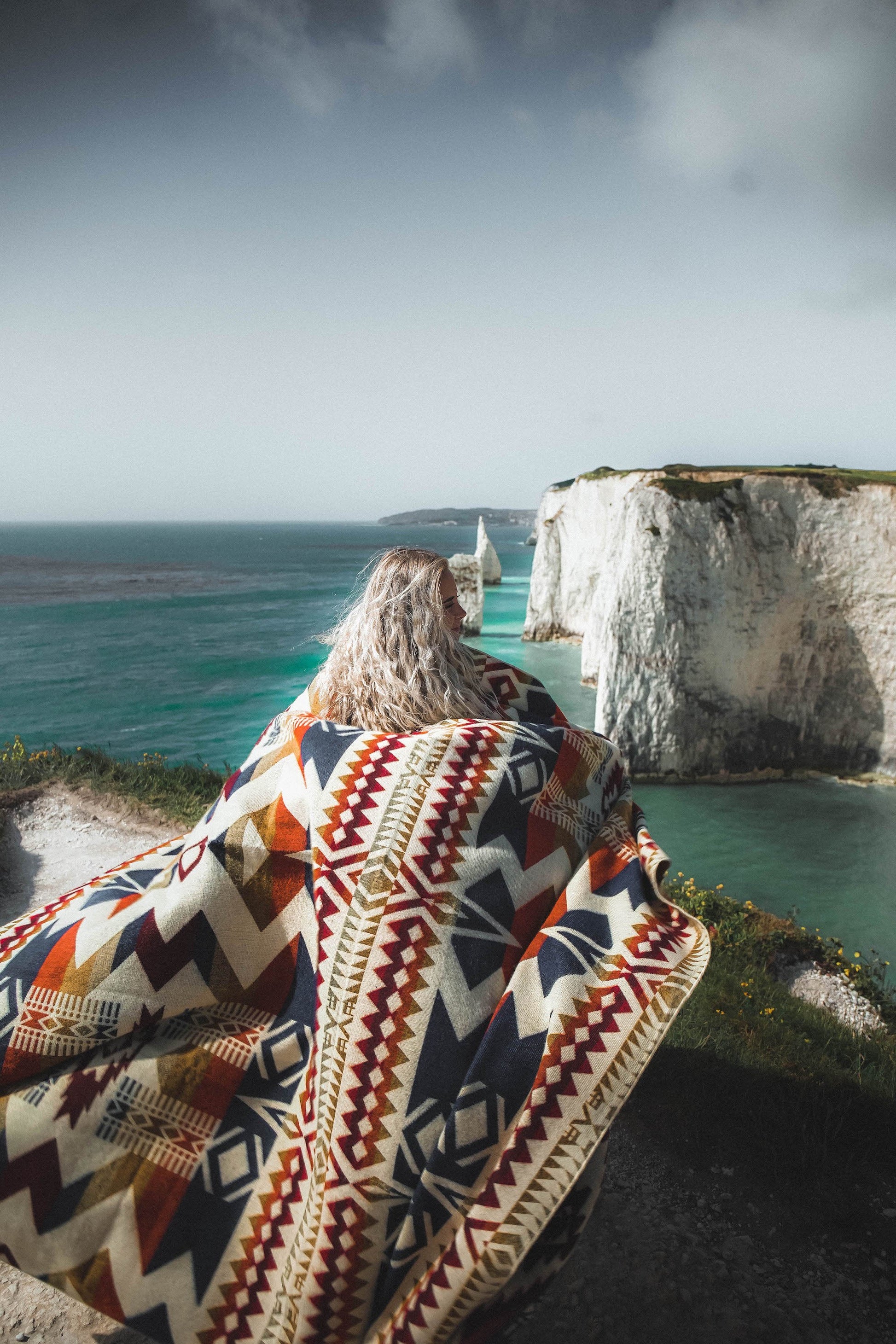 Awa Blanket in Vibrant Autumn colors with reversible design handcrafted in Ecuador from recycled hypoallergenic materials perfect for home decor and camping