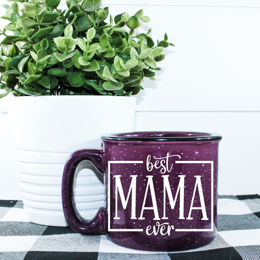 15 oz ceramic campfire mug with 'Best Mama Ever' design in durable vinyl print. Microwave safe, sturdy build, ideal for coffee, tea, or cocoa. Hand wash recommended.