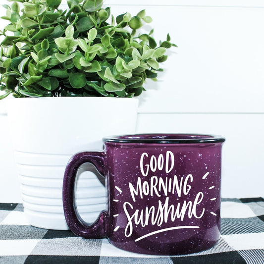 15 oz ceramic campfire mug with 'Good Morning Sunshine' vinyl design. Microwave safe and ideal for coffee, tea, or cocoa. Hand wash recommended to maintain print quality.